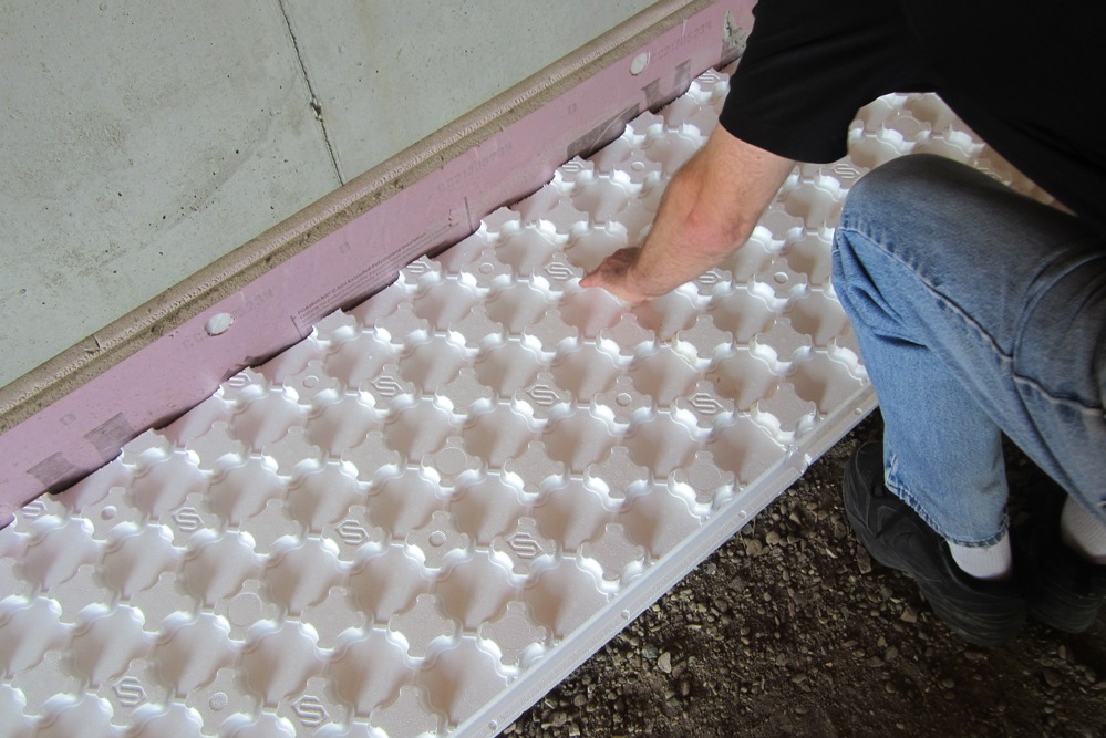 Worker installing Heat Sheet radiant flooring system