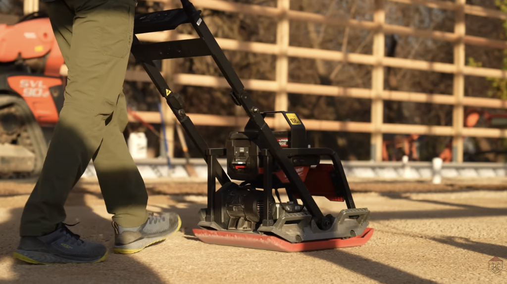 A vibratory plate compactor locks the gravel base into place — the final step in creating a stable, uniform surface for Heat-Sheet® Heavy panels.